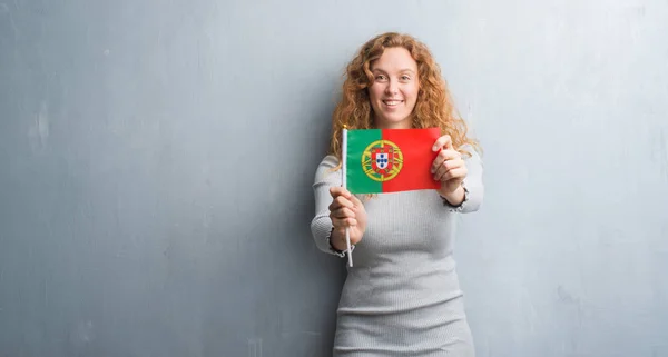 Unga Rödhårig Kvinna Över Grå Grunge Väggen Hålla Portugals Flagga — Stockfoto
