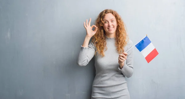 Młody Rude Kobiety Ponad Szary Tło Ściany Trzymając Flagi Francji — Zdjęcie stockowe