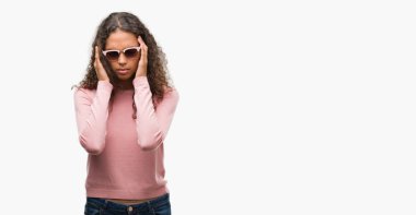 Güzel genç İspanyol kadın giyiyor güneş gözlüğü ile baş ağrısı için kafasına çünkü el stres. Migren muzdarip.