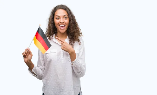 ドイツの旗を手と指で指している非常に満足して保持している若いヒスパニック系女性 — ストック写真