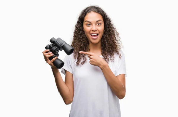 Young Hispanic Woman Looking Binoculars Very Happy Pointing Hand Finger — Stock Photo, Image