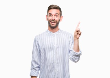 Kameraya bakarak yan el ve parmak ile işaret eden genç yakışıklı adam yüzünde kocaman bir gülümseme ile izole arka plan üzerinde.