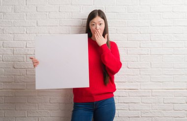 Afiş kapak ağız el için hata, ifade korku, utanç ile şok ile tutarak tuğla duvarın üzerinden Genç Çinli kadın sessizce, gizli kavramı korkuttu
