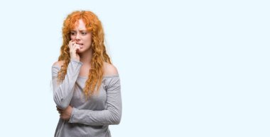 Stresli ve gergin elle çivi ısırma ağzına arayan genç Kızıl saçlı kadın. Anksiyete sorunu.