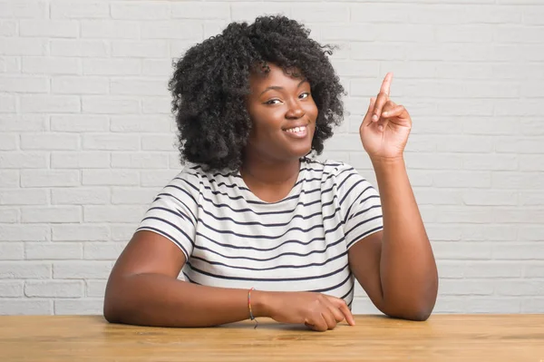 Unga Afroamerikanska Kvinnan Sitter Bord Hemma Pekar Finger Uppåt Med — Stockfoto
