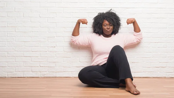 Young African American Woman Sitting Floor Home Showing Arms Muscles — Stock Photo, Image