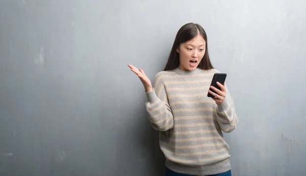 Young Chinese Woman Grey Wall Looking Smartphone Very Happy Excited — Stock Photo, Image