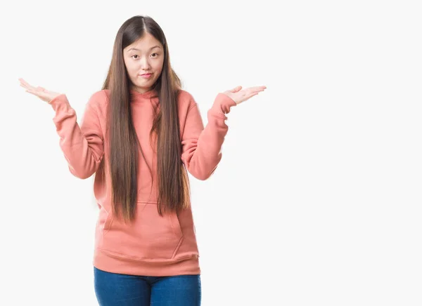 身に着けている腕と手を上げてスポーツ Sweathshirt 無知と混乱式分離の背景の上の若い中国の女性 疑いのコンセプト — ストック写真