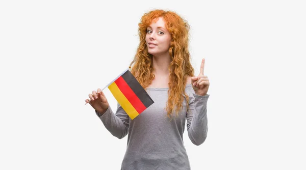 Young Redhead Woman Holding Flag Germany Surprised Idea Question Pointing — Stock Photo, Image