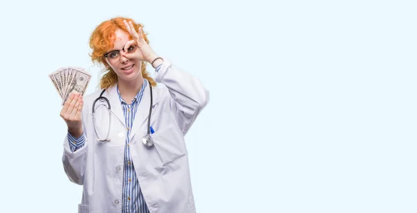 Jovem Médico Ruiva Mulher Segurando Dólares Com Rosto Feliz Sorrindo — Fotografia de Stock