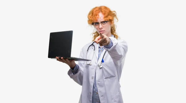 Jovem Mulher Médica Ruiva Segurando Laptop Computador Apontando Com Dedo — Fotografia de Stock