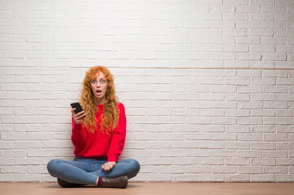Junge Rothaarige Frau Sitzt Über Backsteinmauer Und Telefoniert Erschrocken Mit — Stockfoto