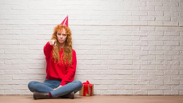 Young Redhead Woman Sitting Brick Wall Wearing Birthday Hat Pointing — Stock Photo, Image