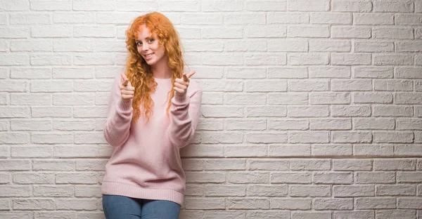 Unga Rödhårig Kvinna Stående Över Tegelvägg Pekande Fingrar Till Kamera — Stockfoto