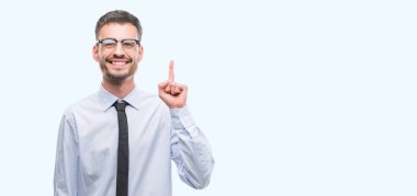 Genç iş adamı bir fikir ya da soru işaret parmağı ile gülen yüz, sürpriz bir numara