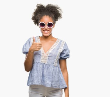 Hareketi el ile mutlu yaşasın yapıyor izole arka plan üzerinde gözlük takan genç afro Amerikalı kadın. Kameraya bakarak başarı gösteren ile ifade onaylama.