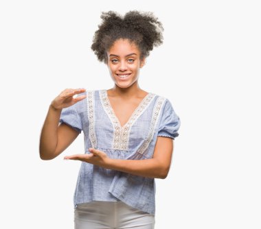 İzole arka plan ile büyük ve büyük boy işaret, ölçü birimi sembol gösteren el eller genç afro Amerikalı kadın. Kameraya bakarak gülümsüyordu. Ölçüm kavramı.