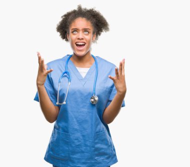 Genç afro Amerikalı doktor kadın izole arka plan çılgın ve kızgın bağırarak ve agresif ifade ve silah kaldırdı bağırıyor. Hayal kırıklığı kavramı.