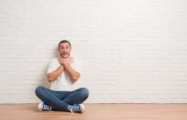 Yerdeki beyaz tuğla üzerinde oturan genç beyaz adam duvar bağırarak ve çünkü boğmak acı kendi ellerimle öldürürüm. Sağlık sorunu. Yaralarından ve intihar kavramı.