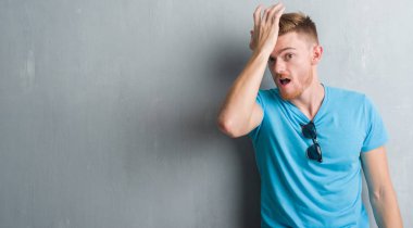 Genç Kızıl saçlı adam kafasına hata için rahat kıyafet el ile sürpriz giyen gri grunge duvarın üzerinden hata hatırlıyorum. Unuttum, kötü bellek kavramı.