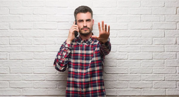 Νεαρός Ενήλικος Μιλώντας Για Τηλέφωνο Που Στέκεται Πάνω Από Λευκό — Φωτογραφία Αρχείου