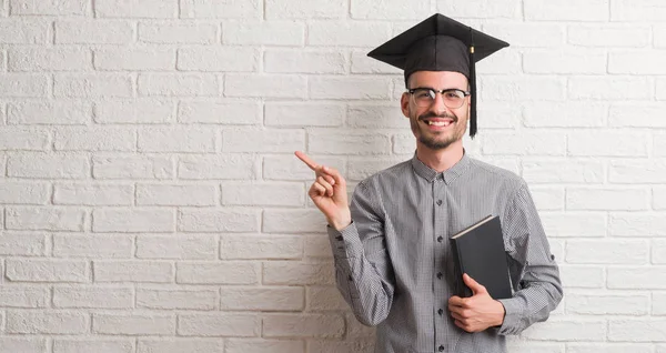 Homem Adulto Jovem Sobre Parede Tijolo Vestindo Tampa Graduação Muito — Fotografia de Stock