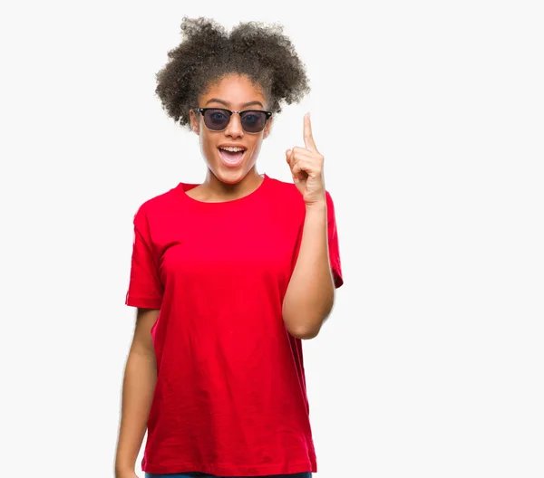 Молодих Афро Американку Окулярах Над Ізольованих Фон Вказівним Пальцем Вгору — стокове фото
