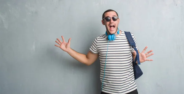 Junger Kaukasischer Student Über Der Grauen Grunge Wand Mit Kopfhörern — Stockfoto