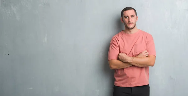 Joven Hombre Caucásico Sobre Pared Gris Grunge Con Expresión Seria —  Fotos de Stock