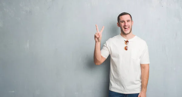 Giovane Uomo Caucasico Sulla Parete Grigia Grunge Indossando Occhiali Sole — Foto Stock