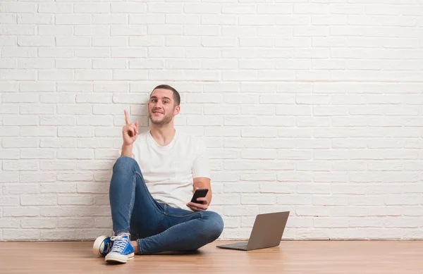 Giovane Uomo Caucasico Seduto Sopra Muro Mattoni Bianchi Utilizzando Computer — Foto Stock