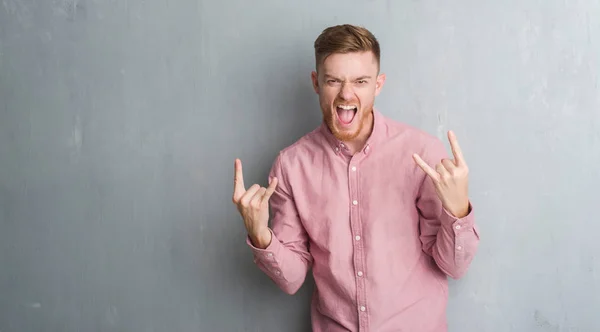 Joven Pelirrojo Sobre Pared Gris Grunge Usando Camisa Rosa Gritando —  Fotos de Stock