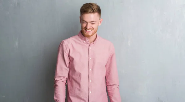 Jovem Ruiva Homem Sobre Parede Grunge Cinza Vestindo Camisa Rosa — Fotografia de Stock