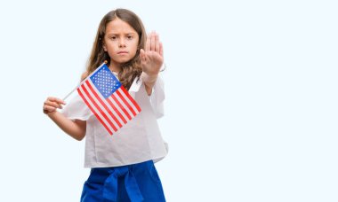 Dur işareti ile ciddi ve kendine güvenen ifade, savunma hareketi yaparken açık el ile Amerika Birleşik Devletleri bayrağı tutarak esmer Latin kız