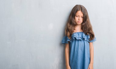 Grunge genç İspanyol çocuk depresyonda duvar gri ve kızgın ve korkmuş ağlıyor sıkıntı için endişeleniyorum. Üzgün ifade.