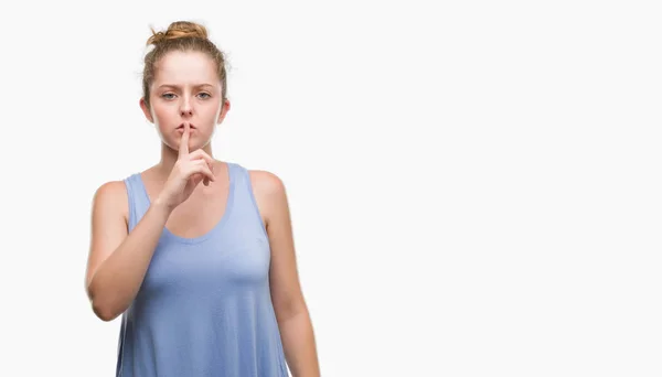 若いブロンドの女性は 唇に指で静かにするように求めています 沈黙と秘密の概念 — ストック写真