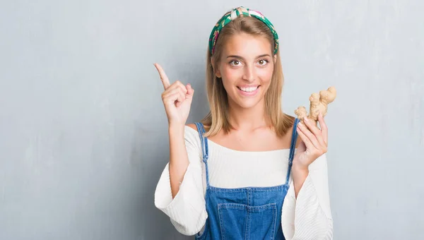 Vacker Ung Kvinna Över Grunge Grå Vägg Håller Färsk Ingefära — Stockfoto