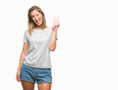 Genç güzel kadın mutlu yüz zafer işareti yaparken kameraya göz kırpıyor ile gülümseyen izole arka plan yüzünden. İki numaralı.