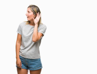 Genç güzel kadın bir işitme söylenti ya da dedikodu için dinleme kulak üzerinde el ile gülümseyen izole arka plan yüzünden. Sağırlık kavramı.