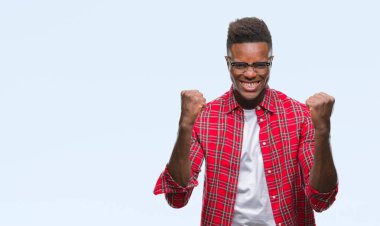 İzole arka plan kutlama üzerinde genç Afro-Amerikan adam şaşırttı ve başarı için kaldırdı kollarını açarak hayret ve gözleri açık. Kazanan kavramı.