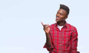 Kameraya bakarak yan el ve parmak ile işaret eden genç Afro-Amerikan adam yüzünde kocaman bir gülümseme ile izole arka plan üzerinde.