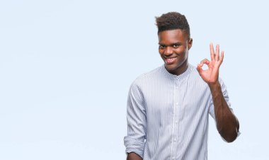 Gülümseyen izole arka plan üzerinde genç Afro-Amerikan adam el ve parmaklar ok işaretiyle yapıyor olumlu. Başarılı ifade.