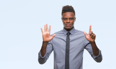 Genç Afro-Amerikalı iş adamı gösterilen ve parmakları ile işaret izole arka plan üzerinde kendinden emin ve mutlu gülümseyerek süre yedi numara.