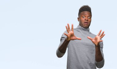 Şokta bağırarak genç Afro-Amerikan adam izole arka plan korkuyor ve korku ifade dur hareketi el ile ile çok korkmuş. Panik kavramı.