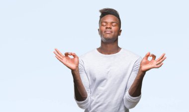Genç Afro-Amerikan adam izole arka plan üzerinde dinlenmek ve gülümseyen gözlerle parmak ile meditasyon jest yapıyor kapalı. Yoga kavramı.