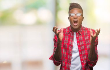 Genç Afro-Amerikan adam izole arka plan çılgın ve kızgın bağırarak ve agresif ifade ve silah kaldırdı bağırıyor. Hayal kırıklığı kavramı.