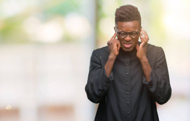 Genç Afro-Amerikan rahip adam yüksek sesle müzik gürültü rahatsız ifade parmaklarıyla kulaklarıyla kapsayan izole arka plan üzerinde. Sağır kavramı.