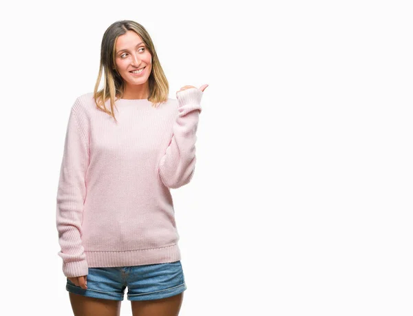探していると親指側に上向きの幸せそうな顔を浮かべて隔離された背景に冬のセーターを着ている若い美しい女性 — ストック写真