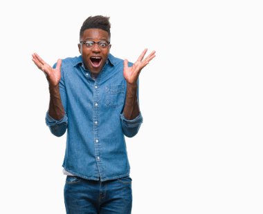 Afrikalı-Amerikalı genç deli kutluyor ve silah ile başarı için heyecanlı çığlık kaldırdı ve açık gözleri hayret izole arka plan üzerinde. Kazanan kavramı