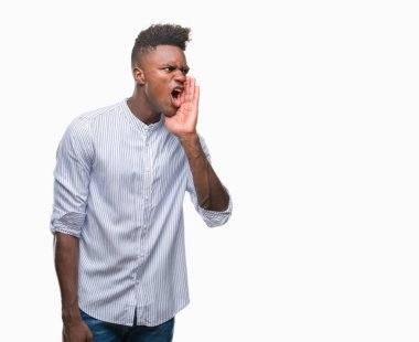 Afrikalı-Amerikalı genç bağırarak ve ağzı üzerinde el ile yan için çığlık izole arka plan üzerinde. İletişim kavramı.